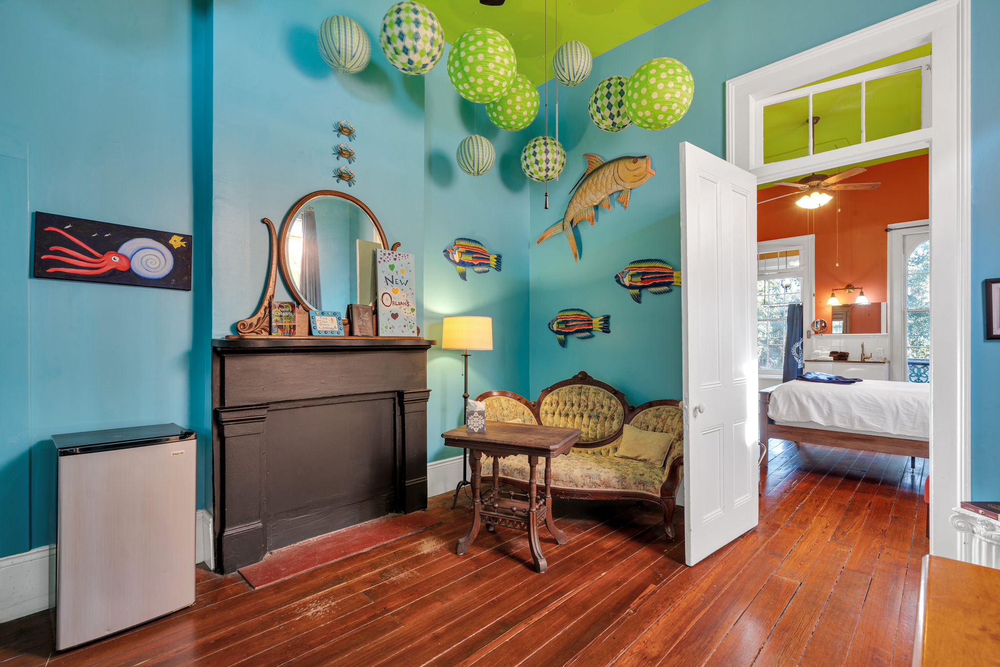 This cozy living area features bold local décor, vintage touches, and an open flow into the bedroom, creating a bright and welcoming atmosphere.