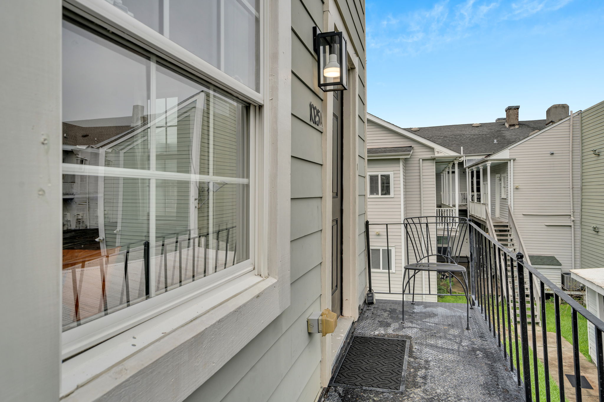 Quiet side entry with seating and a view of the shared courtyard.
