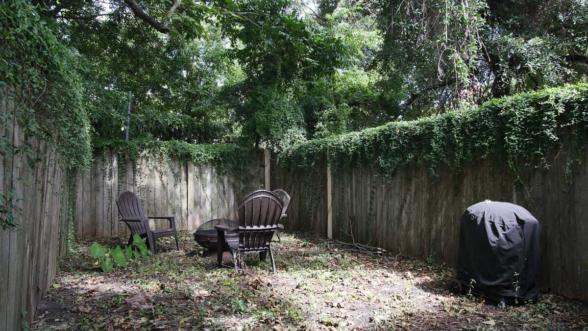 Backyard with seating arrangements with a fire pit.