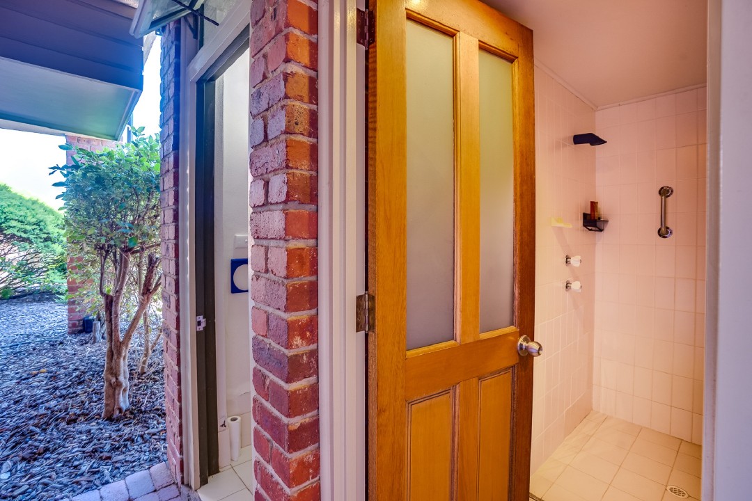 Secondary bathroom is steps from the rear door – ideal for rinsing off sand after beach visits before re-entering the apartment.
