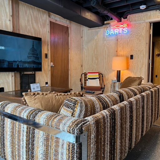 Game room lounge area with comfortable seating and TV