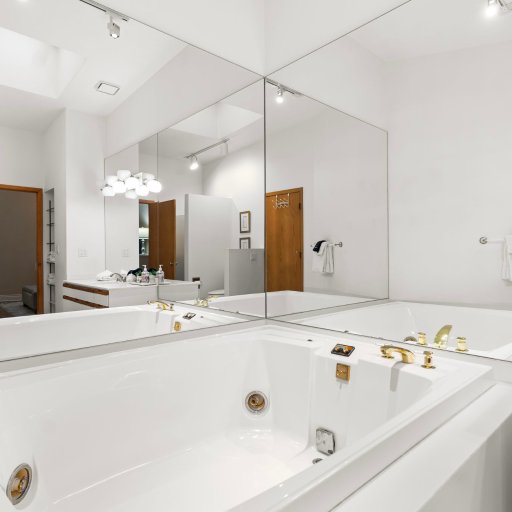 Bathroom 1: jetted corner tub with full mirror surround.