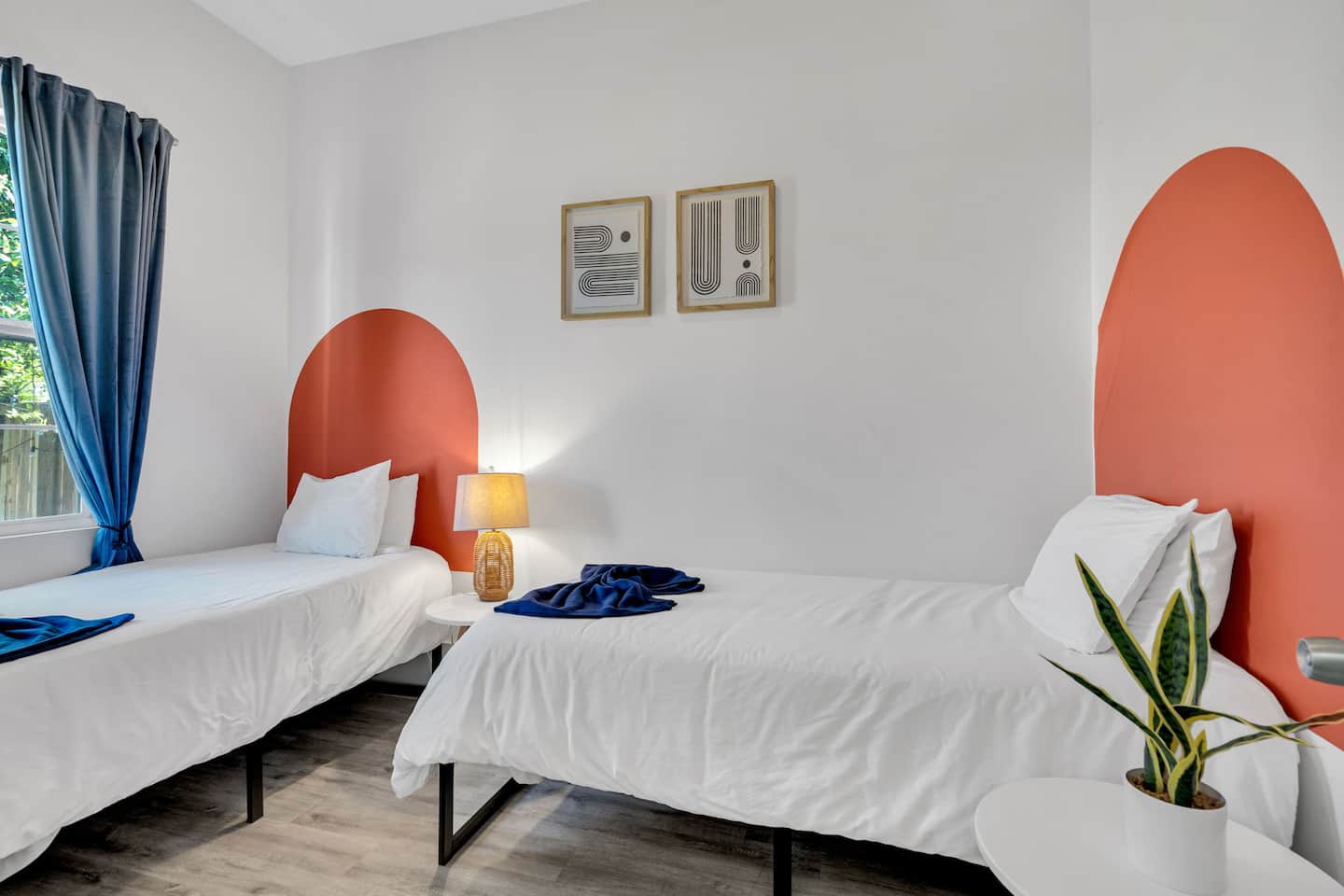 This stylish twin bedroom is designed for both comfort and personality! The warm terracotta arches add a playful touch, while the crisp white bedding and natural decor bring a fresh, modern feel.