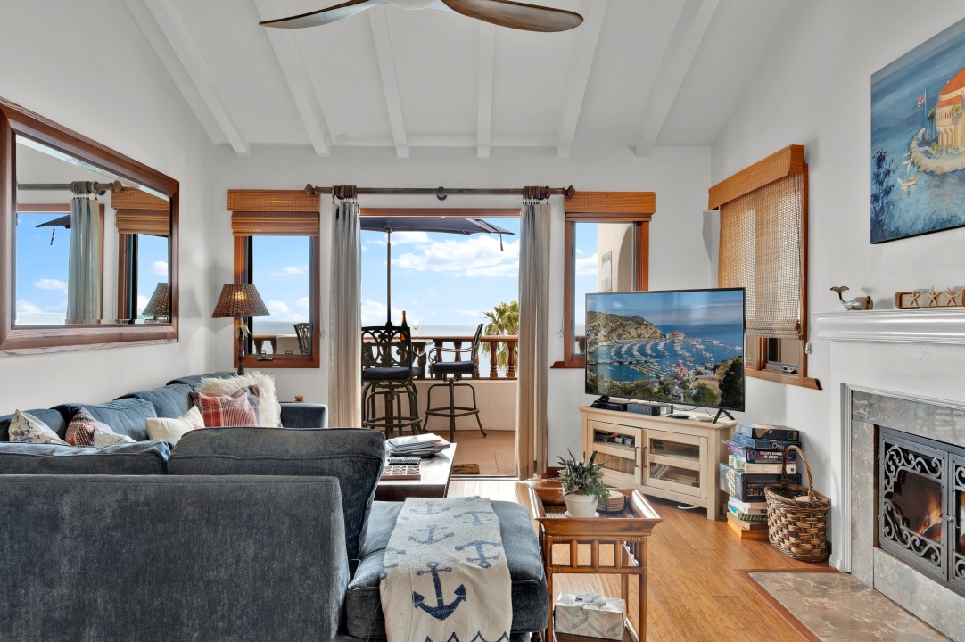 Open living room with large smart TV and wood flooring opens to a ...