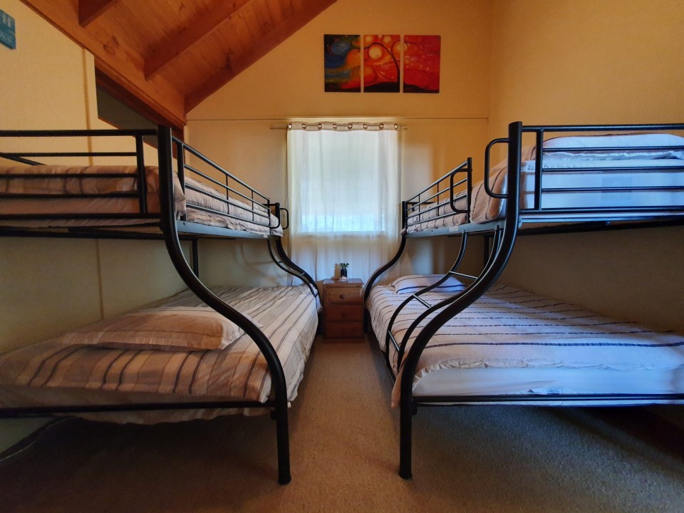 Three well-appointed bedrooms, including two queen beds and two tri-bunks, catering to families, couples, and small groups with ease.