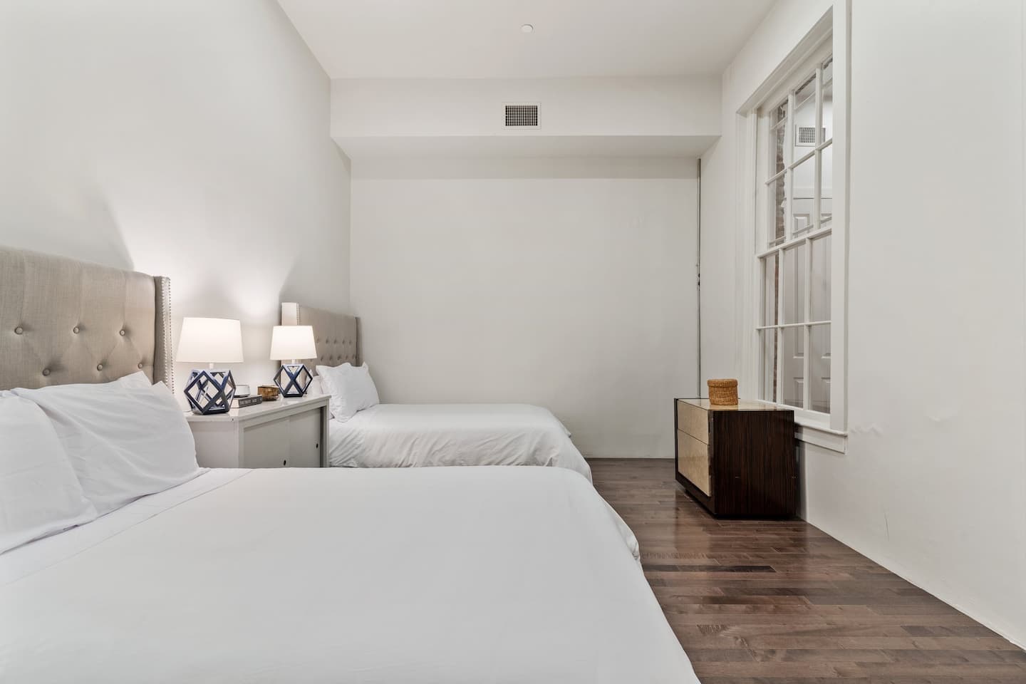 Bedroom with two full sized beds| en suite bathroom in unit 102