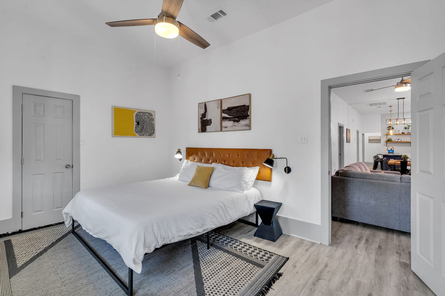 Modern comfort meets cozy elegance! This stylish bedroom features a plush tufted headboard, artistic decor, and warm lighting—perfect for unwinding. Plus, enjoy seamless access to the beautifully designed living space!